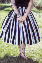 Waist-down view of the Bella swing skirt in black and white Mark Stripe sateen with lace-up sandals