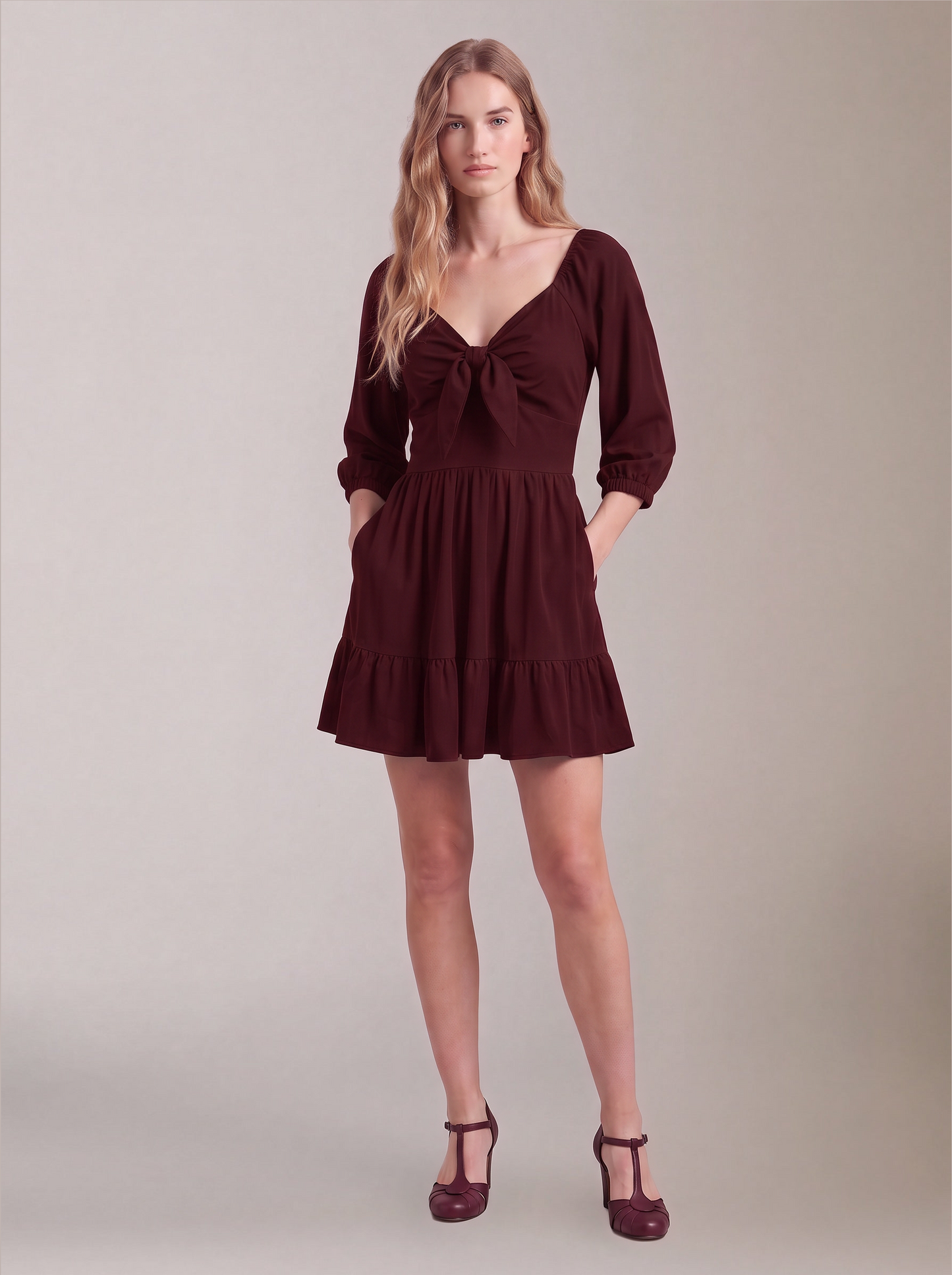 Molly Mini dress in burgundy worn with hands in the deep-set skirt pockets, by Pinup Girl Clothing.