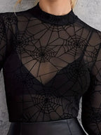Close-up of the black sheer mesh mock neck with spiderweb print