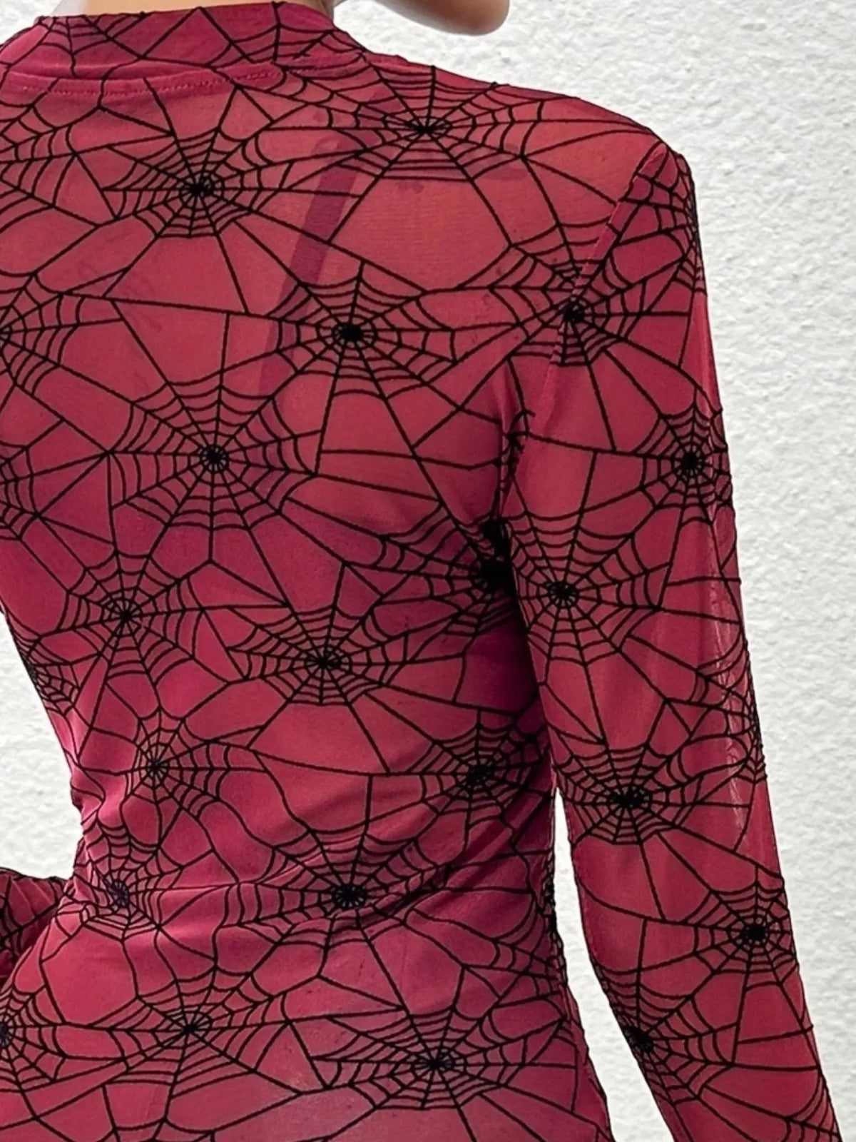 Close-up of the flocked spiderweb print on burgundy mesh