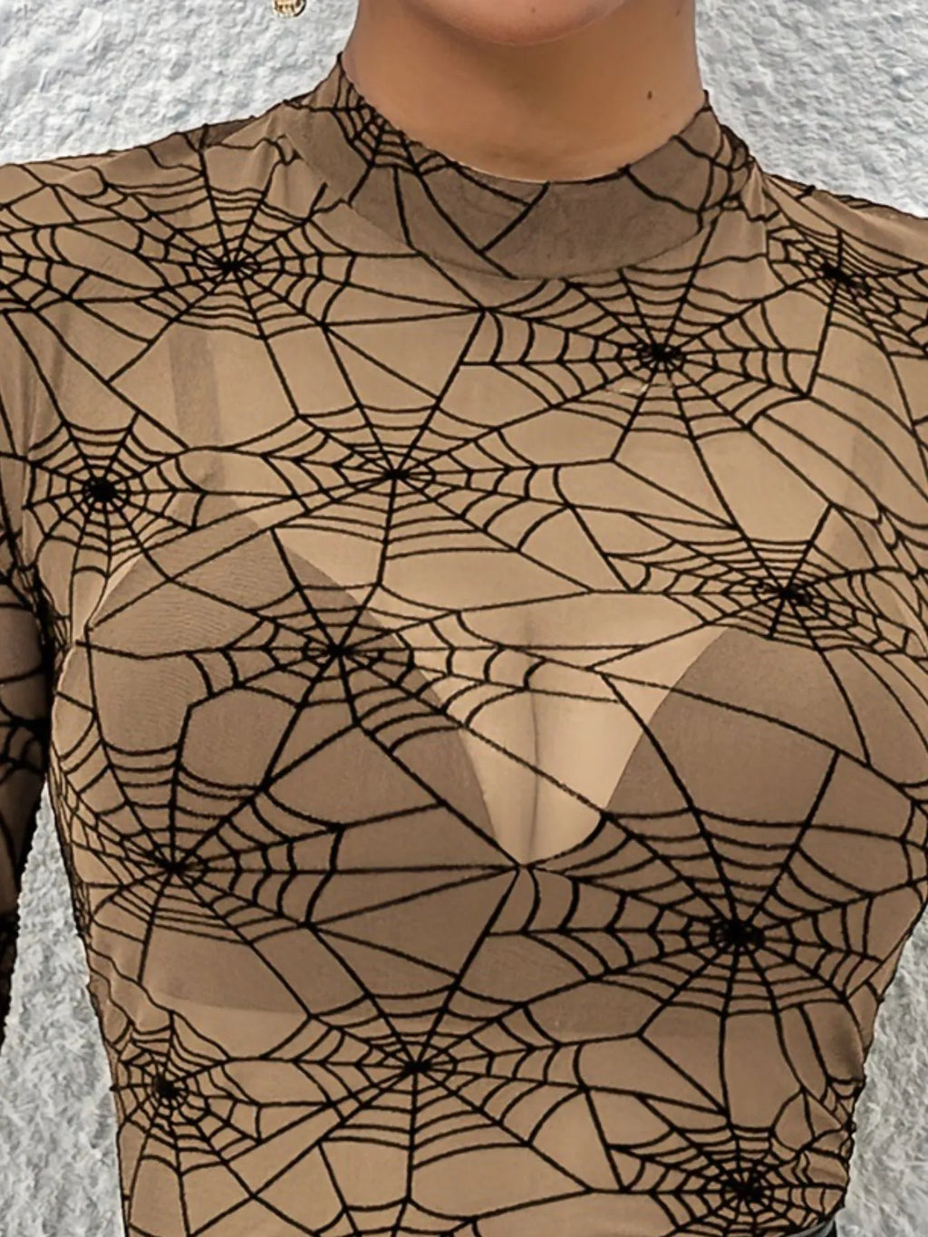 Close-up of the khaki mesh mock neck with black spiderweb print