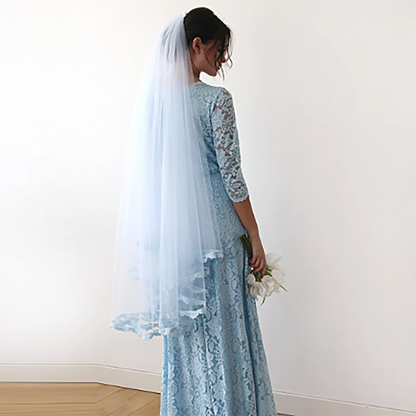 Light blue tulle bridal veil with lace trim shown on the model
