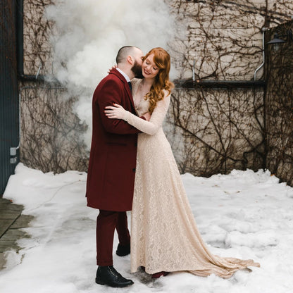 Model in the Colette champagne lace gown with deep V wrap neckline and long lace sleeves