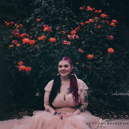 Model in the Seraphine blush lace wrap gown with V neckline, circular cap sleeves and tulle cathedral train