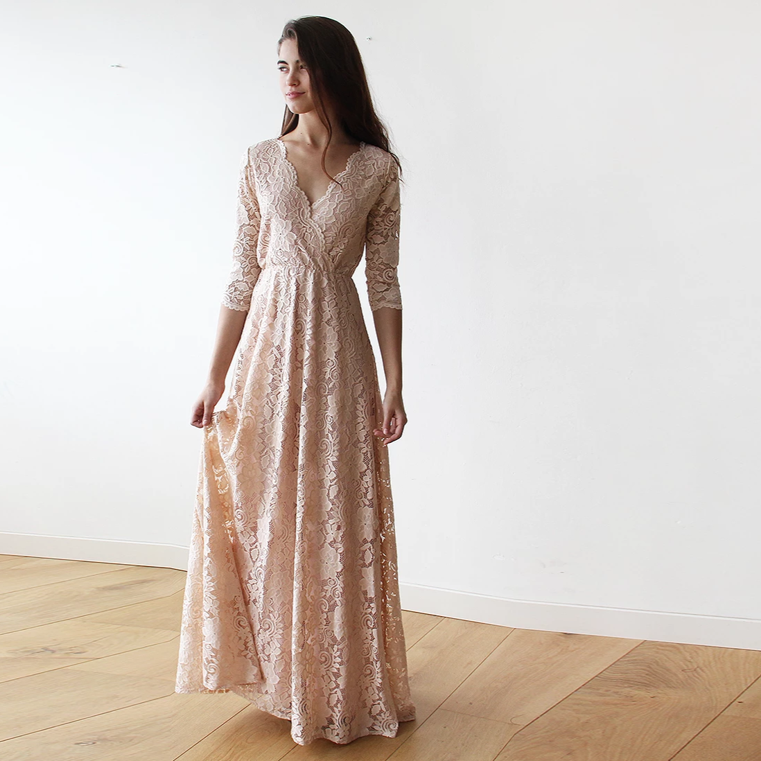 Model in the Ondine blush lace wrap gown with V neckline and three-quarter lace sleeves