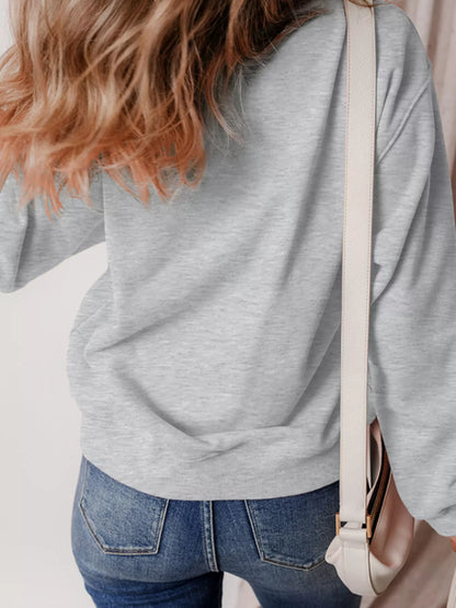 Close-up of the ghost and pumpkin print on the gray Boo Crew sweatshirt