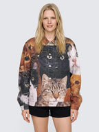 Model wearing the oversized Cat Wrangler Denim Jacket buttoned with arms down, black cat and tabby print, with black high-waisted shorts