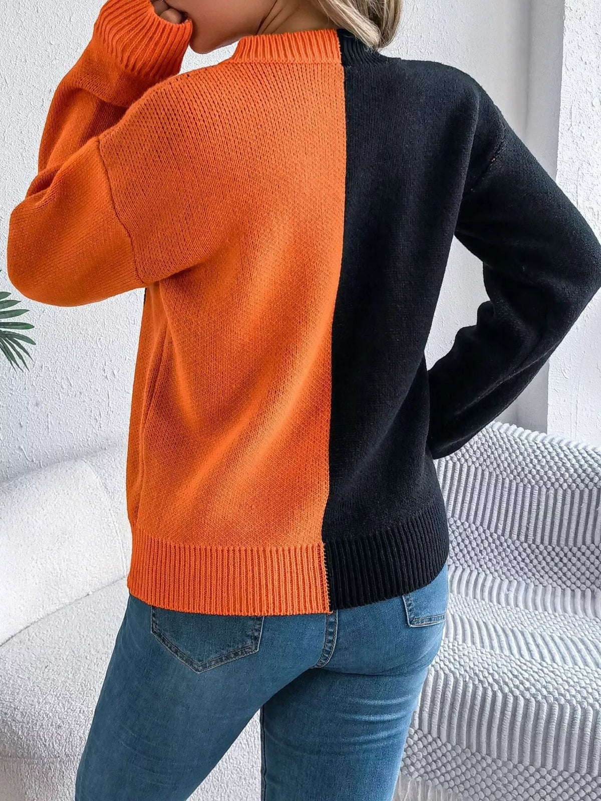Carved two-tone pumpkin face sweater in black and orange, back view