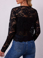 Back view of the black sheer lace open front jacket, showing the scalloped hem over jeans