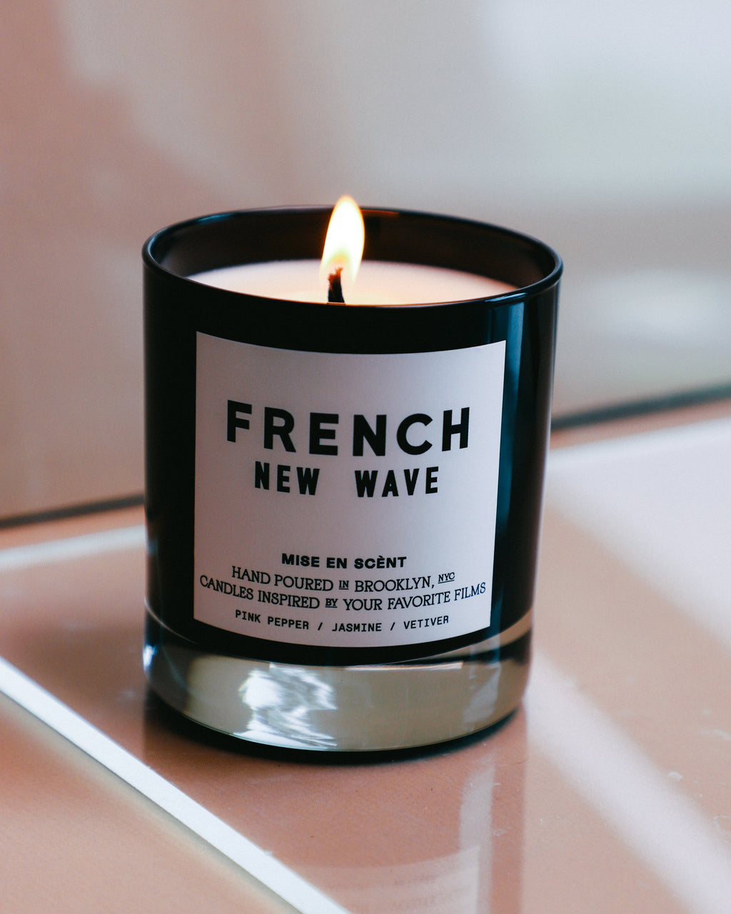 French New Wave candle lit in a black glass jar