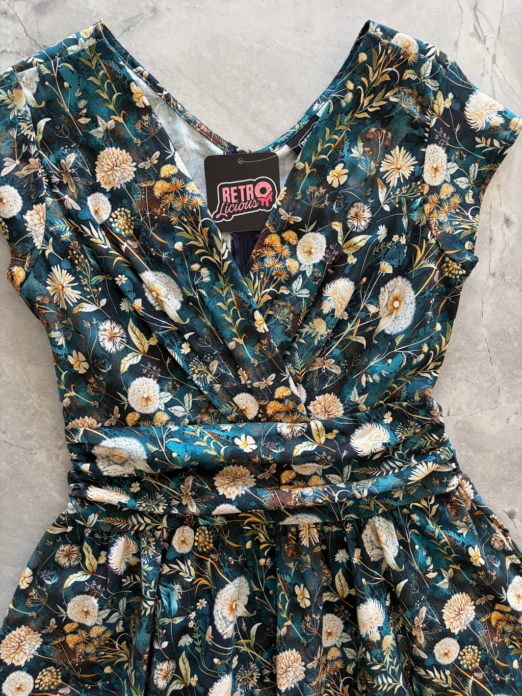 Dandelions Greta Dress, a green floral 1950s swing dress with a surplice neckline