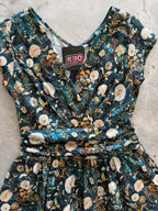 Dandelions Greta Dress, a green floral 1950s swing dress with a surplice neckline