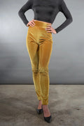 Waist-down view of the Lola high waist velvet leggings in gold with black pointed heels