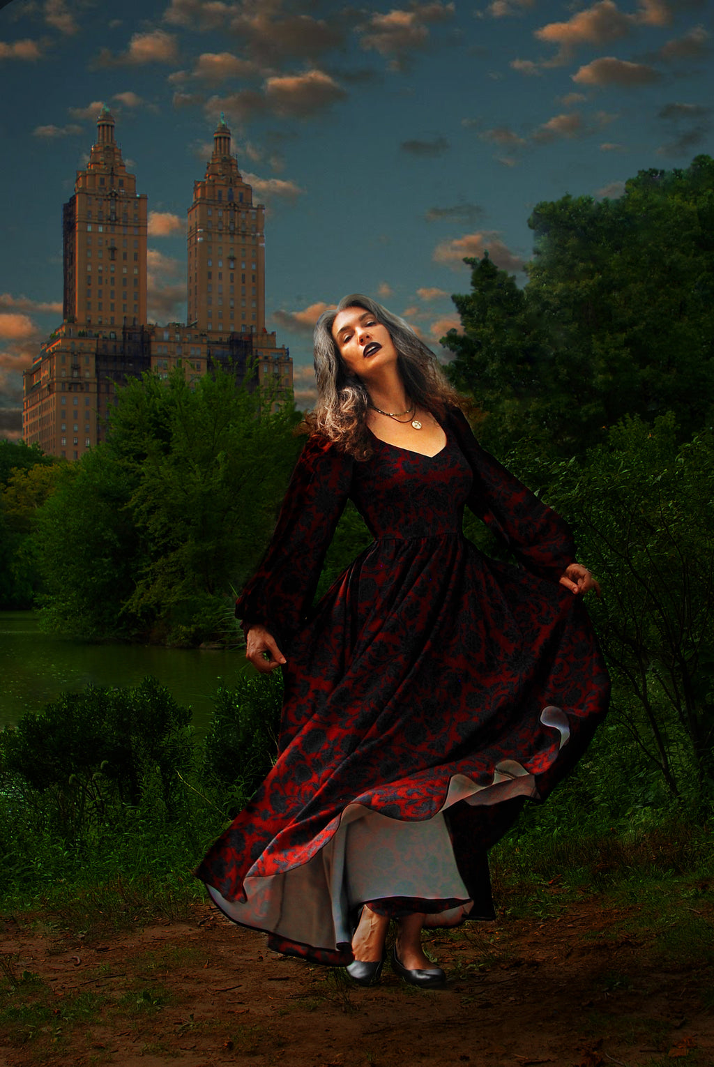 Lucrezia renaissance maxi gown in black on red Capri Floral in motion at dusk, the circle skirt lifting to show the lining