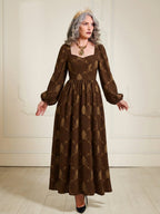 Lucrezia Renaissance Maxi Gown in Brown Grand Trianon styled with a gold crown and statement necklace, billowing bishop sleeves