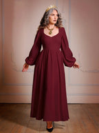 Full-length view of the burgundy Lucrezia renaissance maxi gown worn with a gold crown, showing the sweep of the gathered circle skirt