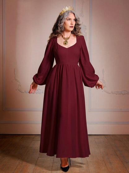 Full-length view of the burgundy Lucrezia renaissance maxi gown worn with a gold crown, showing the sweep of the gathered circle skirt