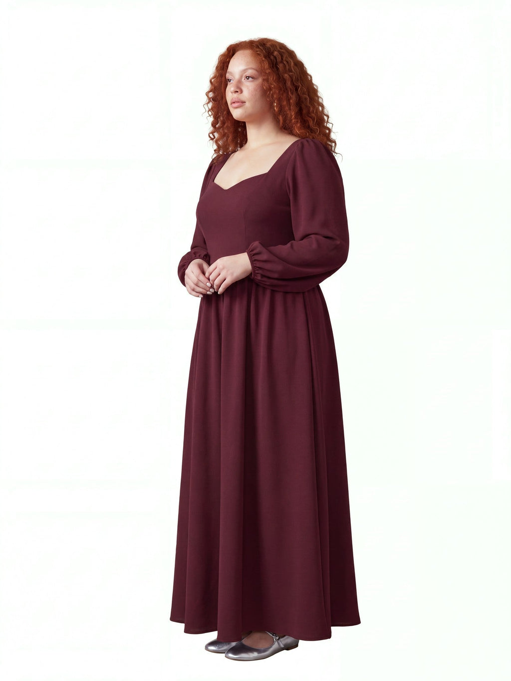 Model in the burgundy Lucrezia renaissance maxi gown, three-quarter view, showing the fitted bodice, cuffed bishop sleeves and the full floor-length skirt