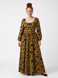 Model wearing the Lucrezia renaissance maxi gown in ochre Capri Floral, black blooms on gold, deep sweetheart neckline and bishop sleeves, front view