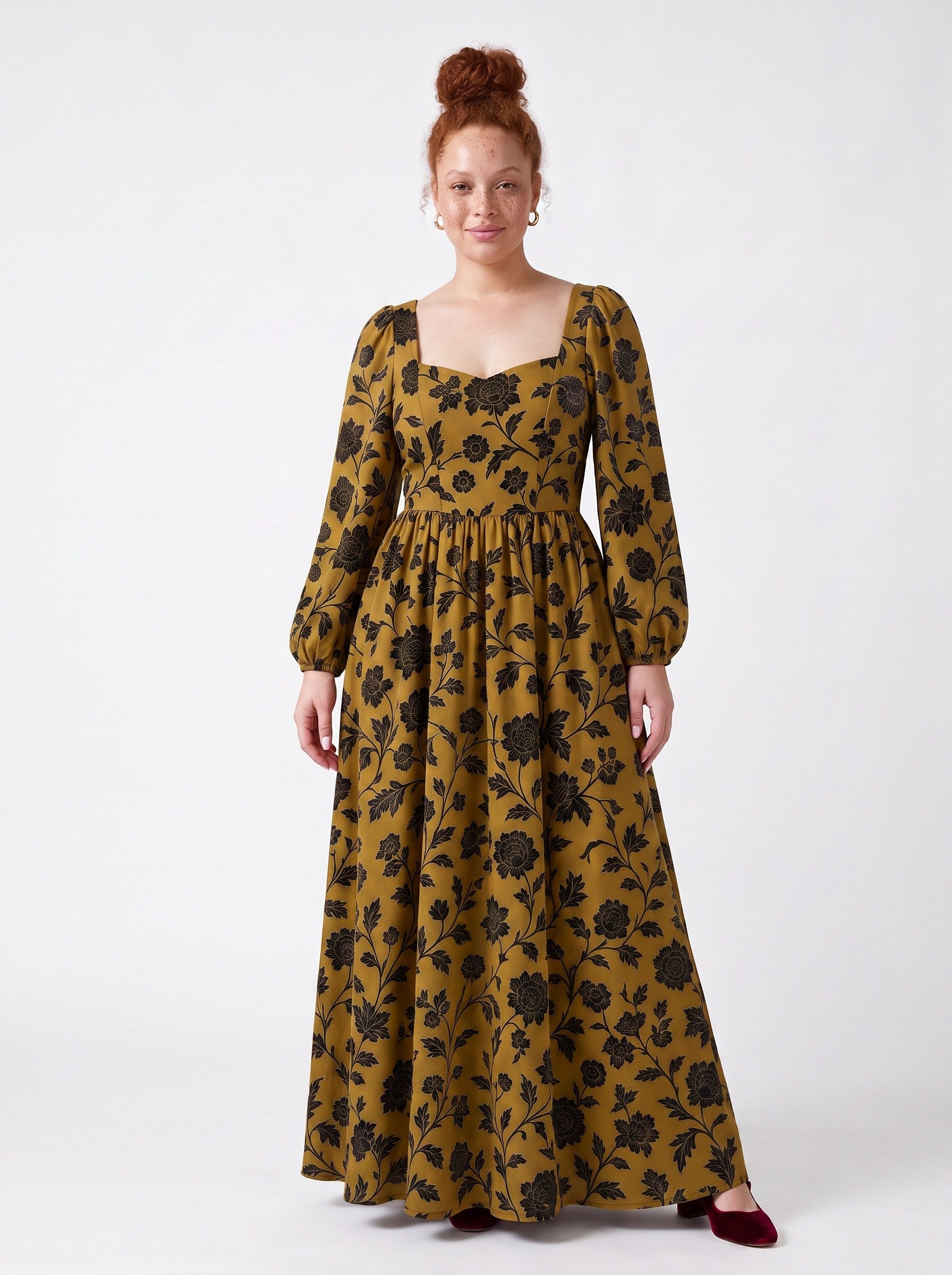 Model wearing the Lucrezia renaissance maxi gown in ochre Capri Floral, black blooms on gold, deep sweetheart neckline and bishop sleeves, front view