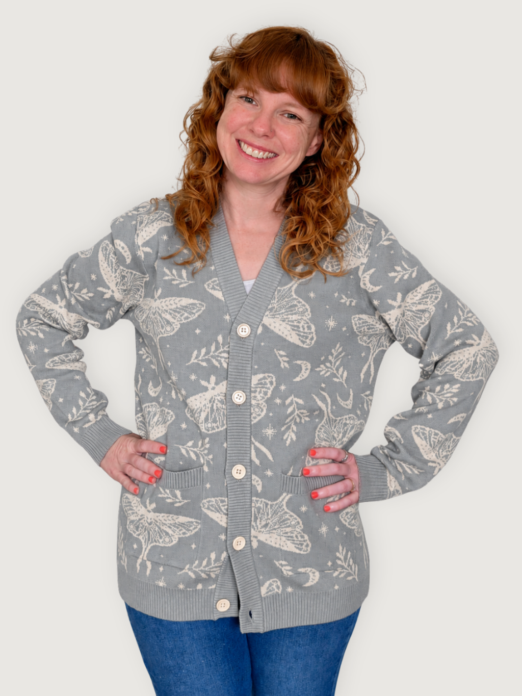 Woman wearing the Luna Moth Cardigan with hands on hips, gray knit with cream moth print