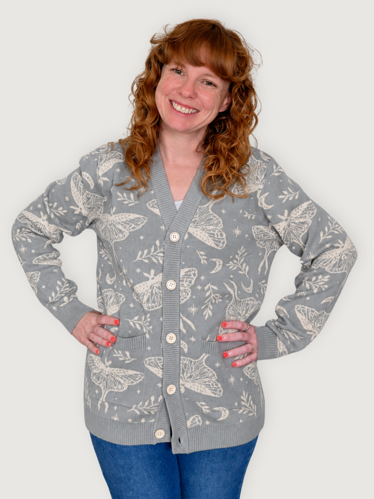 Woman wearing the Luna Moth Cardigan with hands on hips, gray knit with cream moth print