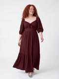 Model laughing in the Molly 70s Maxi Gown in Burgundy, hand on hip, showing the off-the-shoulder-ready neckline and puff sleeves