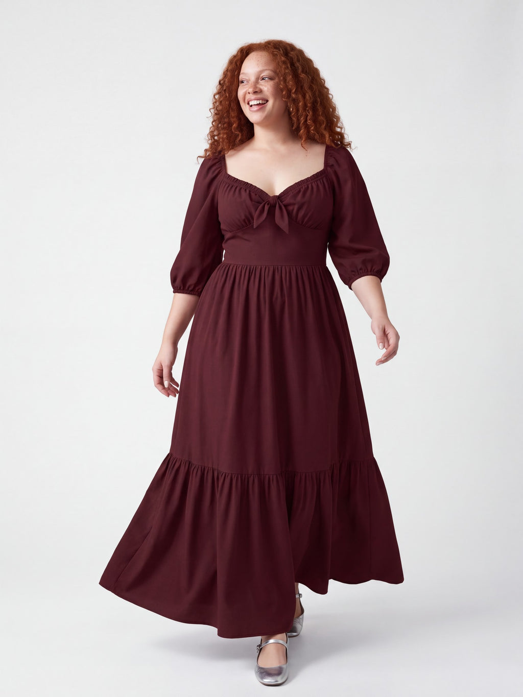 Model walking in the Molly 70s Maxi Gown in Burgundy, the tiered skirt swinging mid-stride