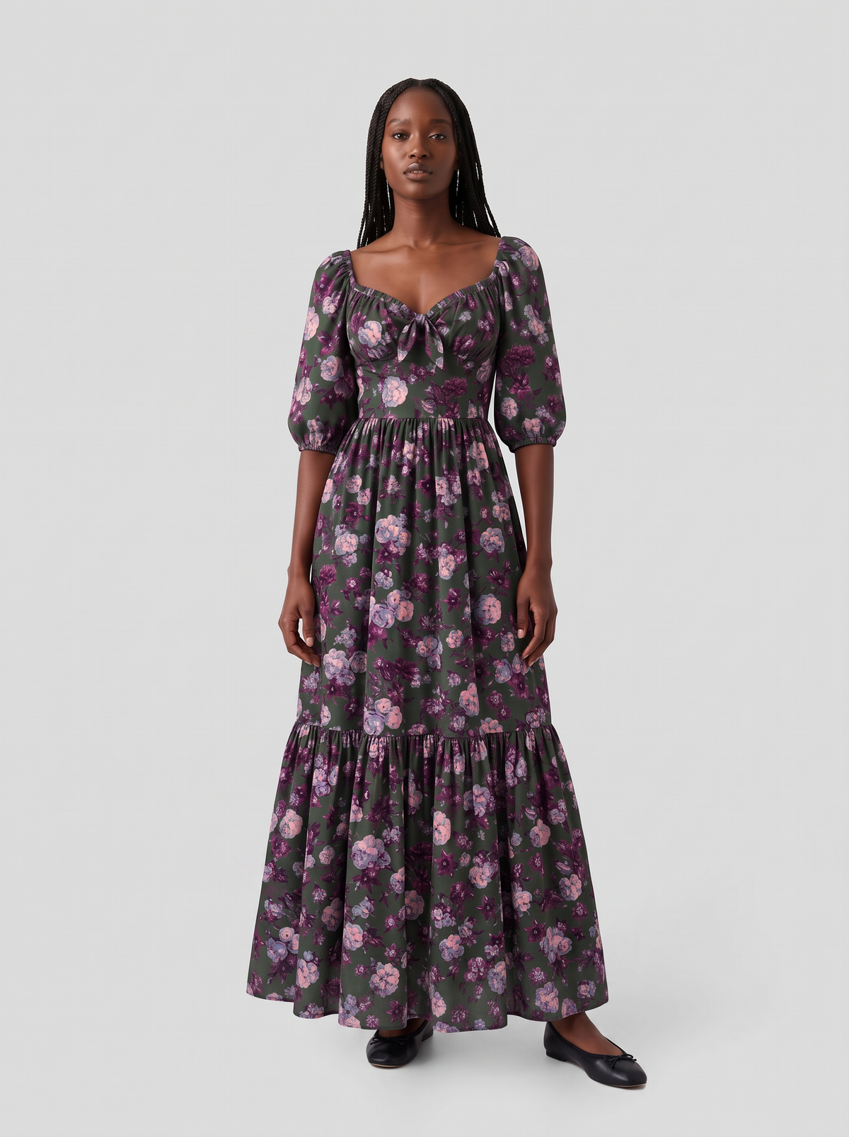 Model in the Molly 70s Maxi Gown in Oil Slick Ambrosia Floral, front view, small lilac and plum roses on dark olive green crepe with 3/4 puff sleeves and an ankle-length tiered skirt over black flats