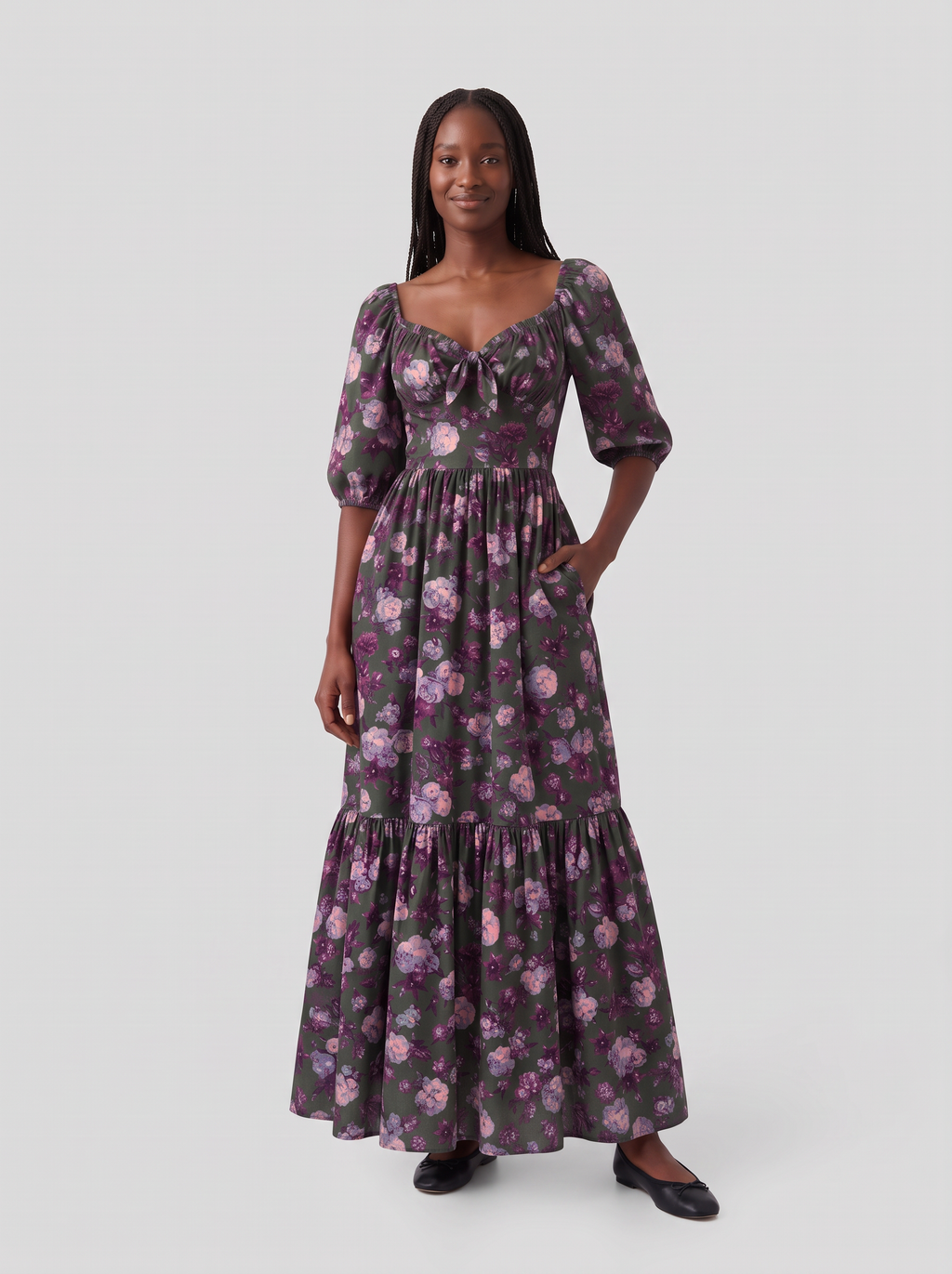 Model with one hand in the deep side pocket of the Molly 70s Maxi Gown in Oil Slick Ambrosia Floral, showing the tie-front sweetheart neckline and gathered bodice