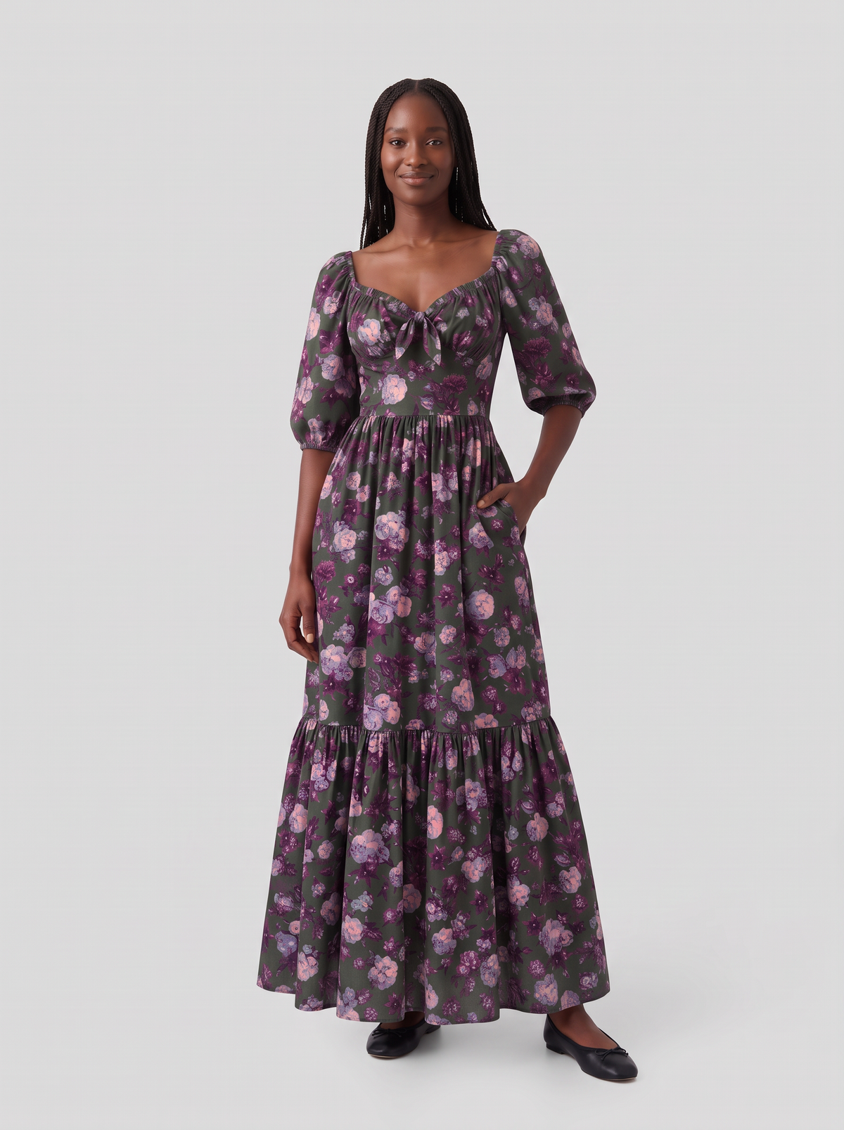 Model with one hand in the deep side pocket of the Molly 70s Maxi Gown in Oil Slick Ambrosia Floral, showing the tie-front sweetheart neckline and gathered bodice