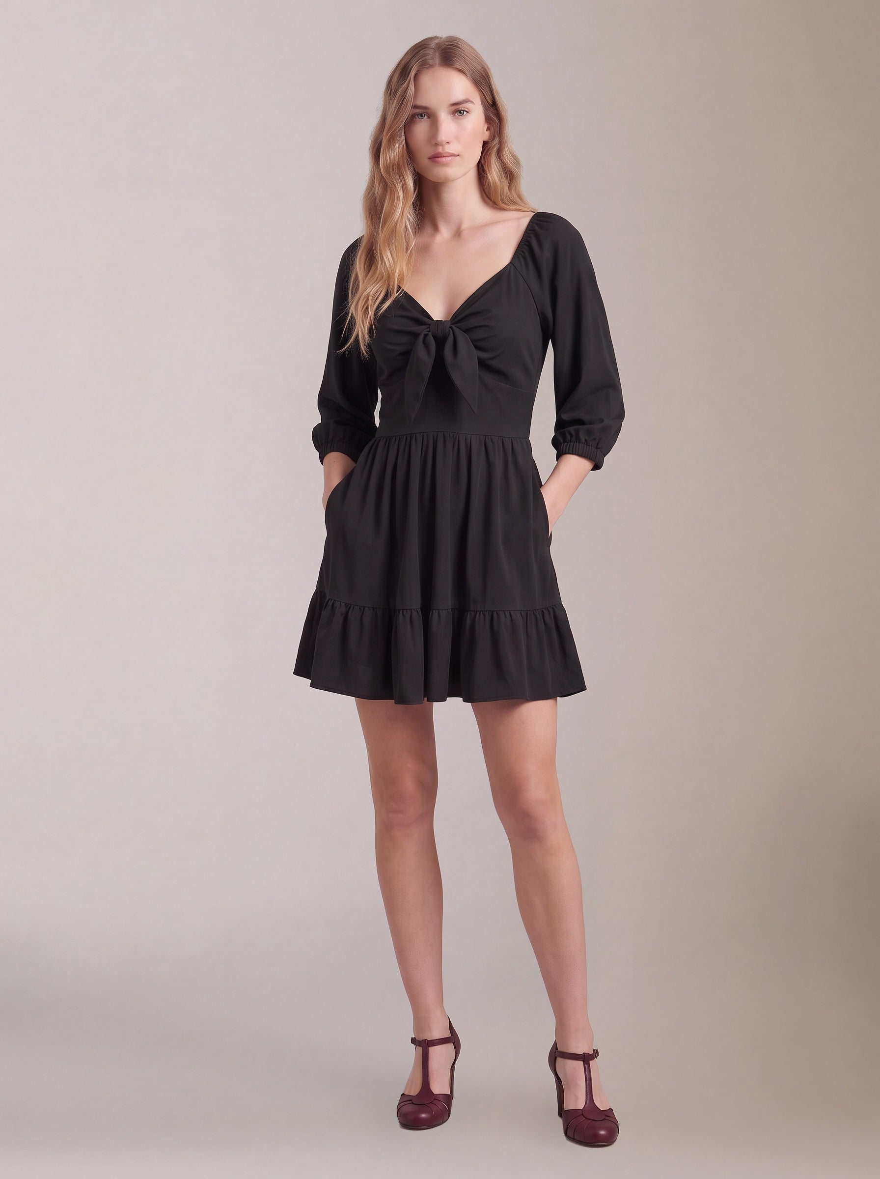 Molly Mini dress in solid black worn with hands in the deep-set skirt pockets, by Pinup Girl Clothing.