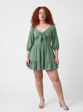 Model wearing the Molly Mini dress in solid mint green, front view, with tie-front bodice and tiered ruffle hem skirt.