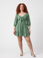 Model wearing the Molly Mini dress in solid mint green, front view, with tie-front bodice and tiered ruffle hem skirt.