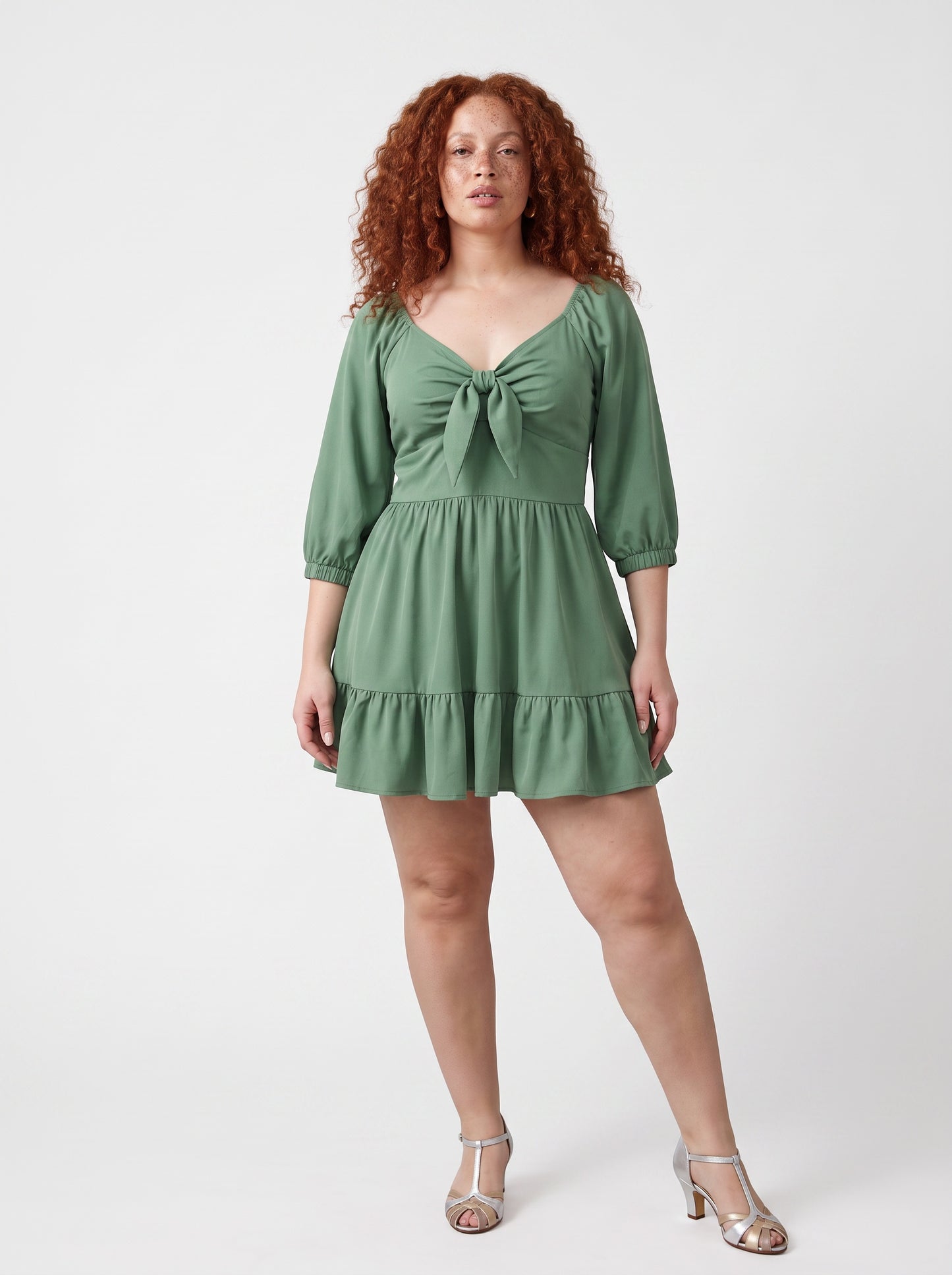 Model wearing the Molly Mini dress in solid mint green, front view, with tie-front bodice and tiered ruffle hem skirt.