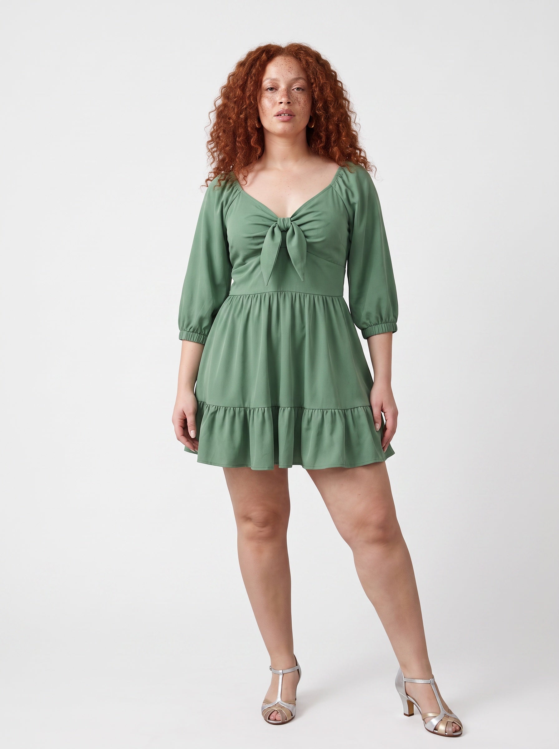 Model wearing the Molly Mini dress in solid mint green, front view, with tie-front bodice and tiered ruffle hem skirt.