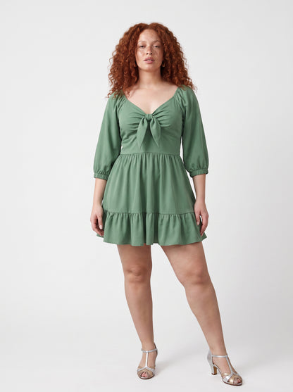 Model wearing the Molly Mini dress in solid mint green, front view, with tie-front bodice and tiered ruffle hem skirt.