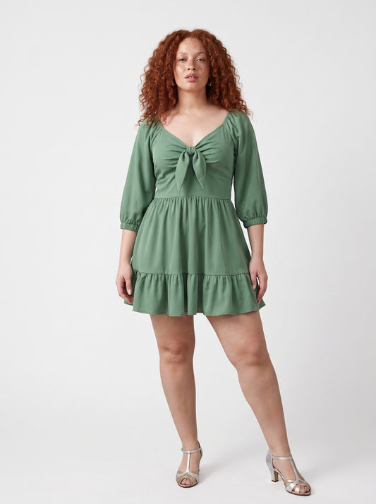 Model wearing the Molly Mini dress in solid mint green, front view, with tie-front bodice and tiered ruffle hem skirt.