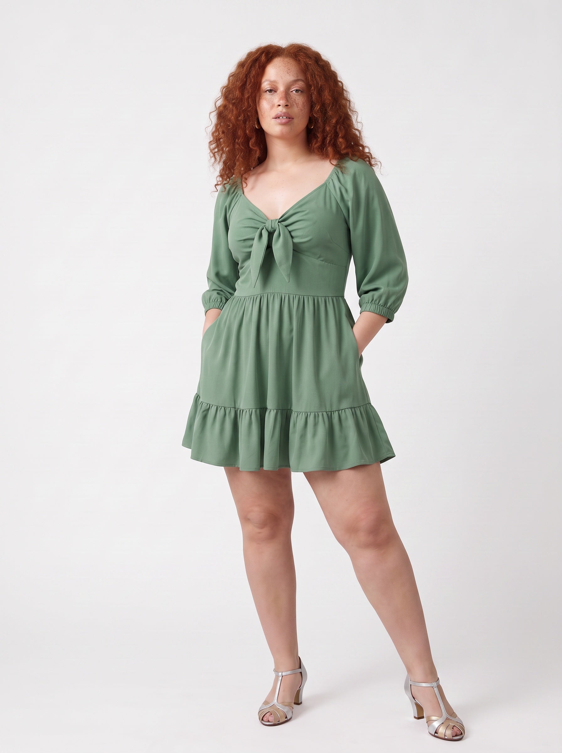 Molly Mini dress in mint green worn with hands in the deep-set skirt pockets, by Pinup Girl Clothing.