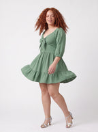 Molly Mini dress in mint green mid-twirl, showing the tiered ruffle hem in motion.