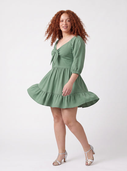Molly Mini dress in mint green mid-twirl, showing the tiered ruffle hem in motion.