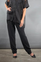 Waist-down view of the Olivia tapered pleat pants in black crepe with black pointed heels