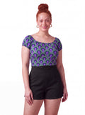 Model wearing the vintage peasant top in the purple and green Room 237 carpet print with black LB high-waisted shorts