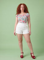 Vintage cherries peasant top and white LB high-waisted shorts by Pinup Girl Clothing, sizes XS to 5X.