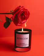 Rom Com candle lit beneath a red rose