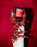 Summer Slasher candle in a hand dripping red glitter