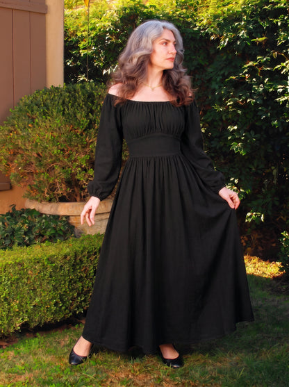 Swann Maxi Dress in solid black, a floor-length maxi with a gathered off-shoulder neckline, long blouson sleeves and a fitted waistband