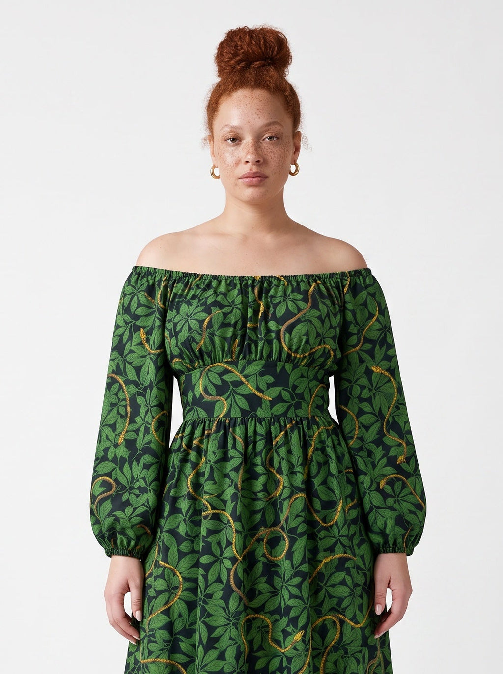 Close up of the Swann Maxi Dress in Black Serpente, gathered off-shoulder neckline and the green and gold serpent print