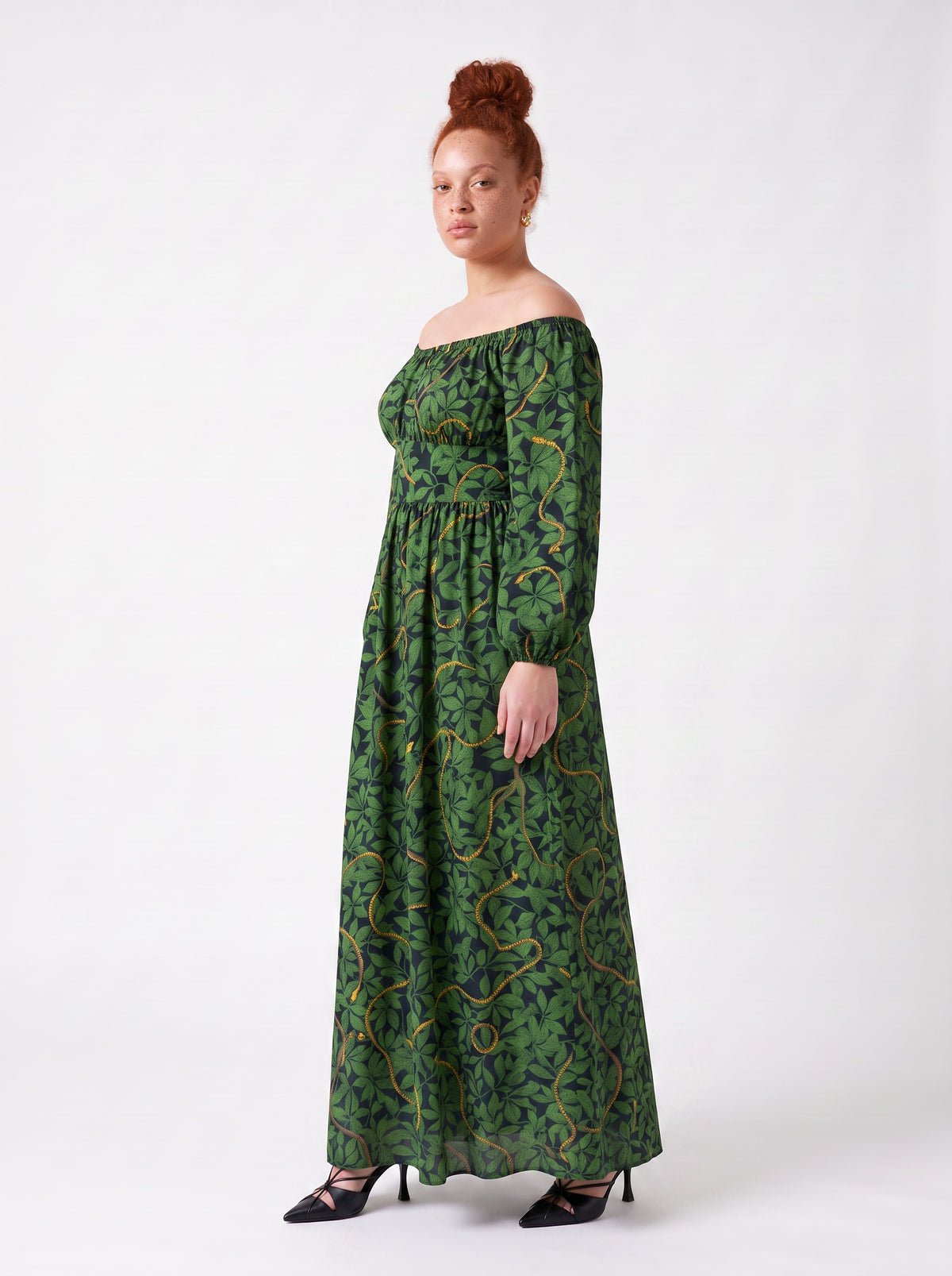 Side view of the Swann Maxi Dress in Black Serpente showing the fitted waistband, blouson sleeves and the sweep of the maxi skirt