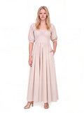 Swann Maxi Dress in Coconut Milk, a warm off-white floor-length maxi with a gathered square neckline worn up on the shoulders, puffed elbow-length sleeves and a fitted waistband